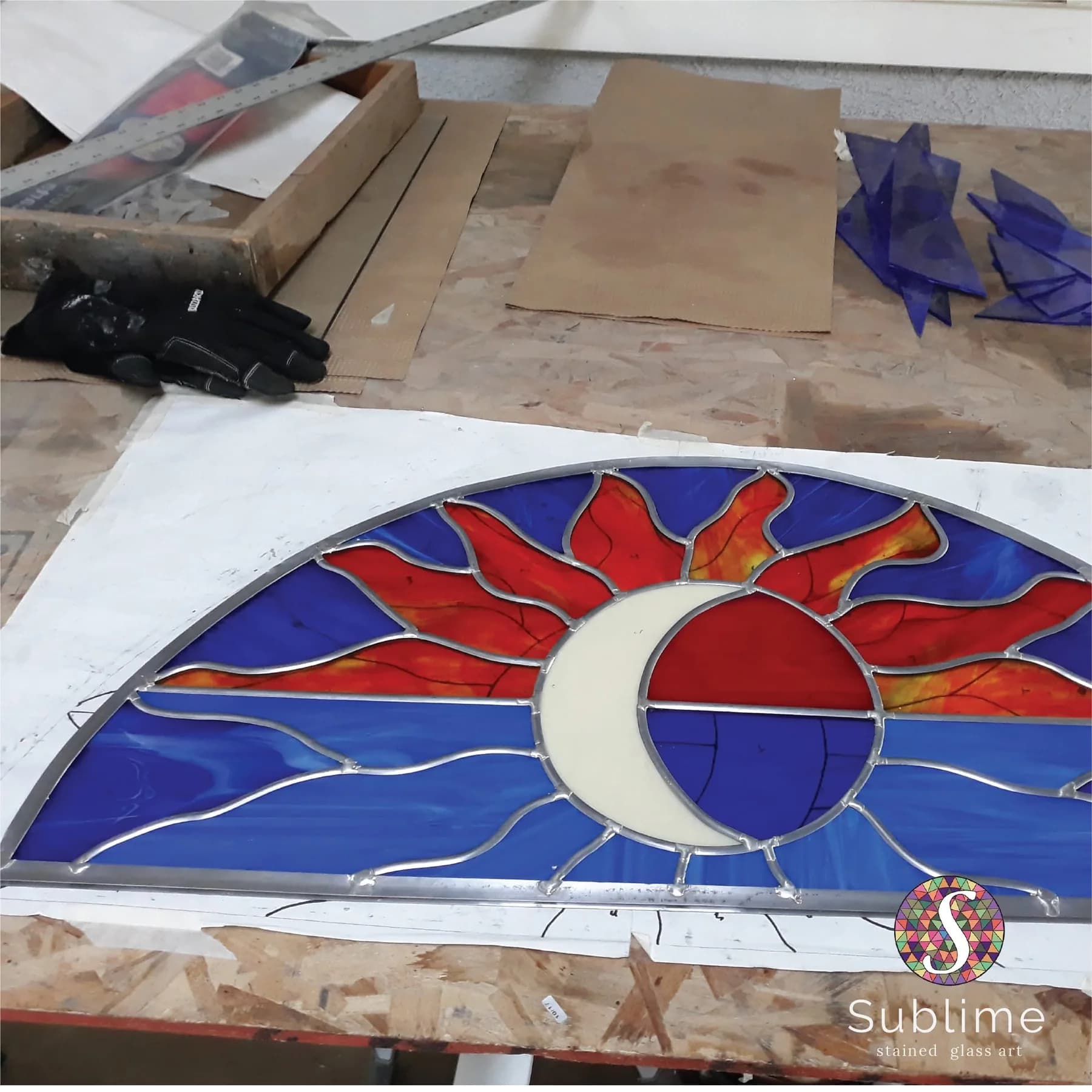 Stained glass panel restoration on a workshop bench before reinstallation
